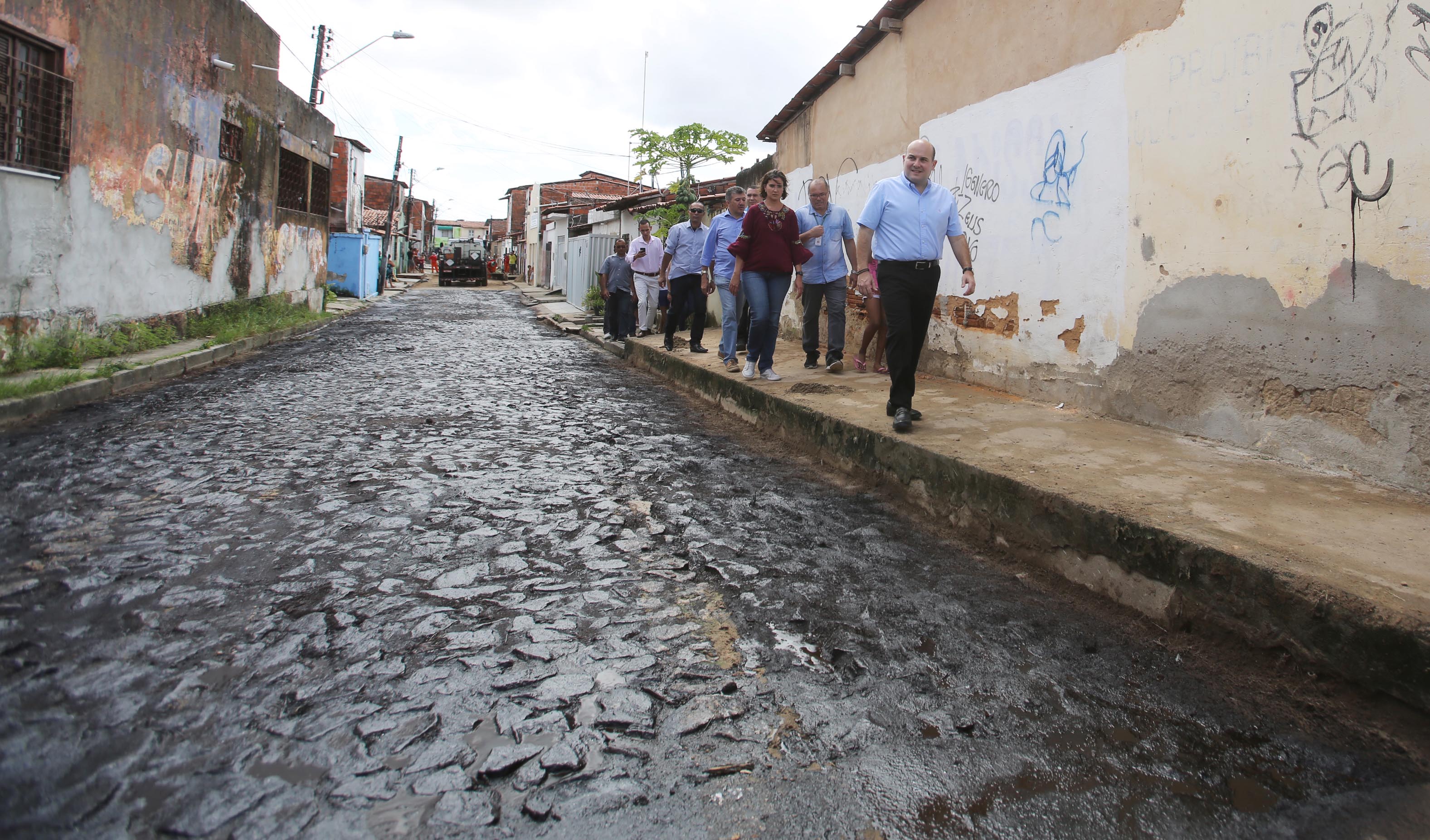 prefeito roberto cláudio observa obra de asfaltamento em rua do bairro genibau